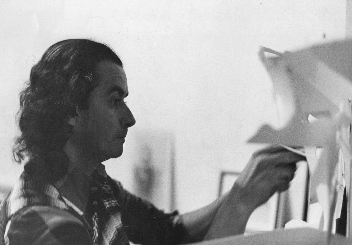 Jorge Castillo working on a sheet pinned to a wall, black-and-white photograph